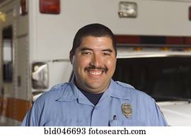 Asian male paramedic in front of ambulance