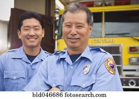 Asian male paramedics in front of ambulance