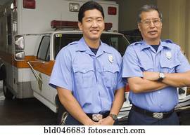 Asian male paramedics in front of ambulance