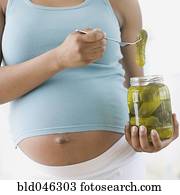 grávida, mulher americana africana, segurando, pickles