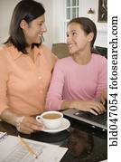 Hispanic mother and daughter smiling at each other