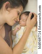 Hispanic mother laying next to baby