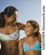 Hispanic mother and daughter smiling at each other