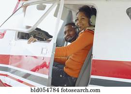 African couple in cockpit of airplane