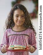 African girl holding plate of cookies