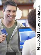 Hispanic man holding up credit card at check out