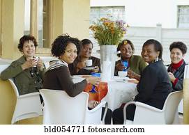 Multi-ethnic women having coffee outdoors