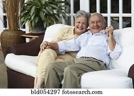 Senior Hispanic couple sitting on sofa