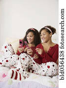 African twin sisters looking at cell phones