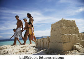 Hispanic family walking past sandcastle