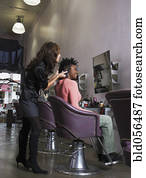 Hispanic hair stylist styling African woman’s hair