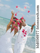 Multi-ethnic couple throwing flower petals in air