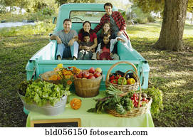 Multi-ethnic family in truck at farm stand