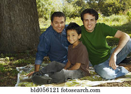 Multi-ethnic family sitting under tree