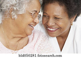 African American mother and adult daughter smiling at each other African American mother and adult daughter smiling at each other