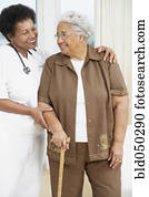 Doctor helping senior African American woman walk