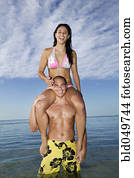 Pacific Islander woman sitting on boyfriend’s shoulders