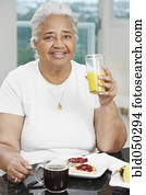 Senior African American woman eating breakfast