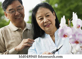 Senior Asian couple pruning flowers Senior Asian couple pruning flowers