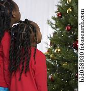 African sisters looking at Christmas tree