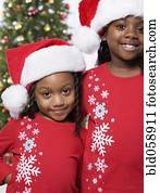 African sisters wearing Santa Claus hats