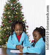 African sisters writing letter to Santa Claus