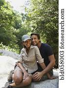 Hispanic couple hugging on rocks