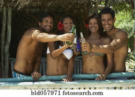 Hispanic couples toasting in beach hut