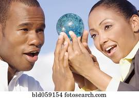Multi-ethnic businesspeople looking at glass orb