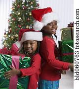 African sisters holding Christmas gifts