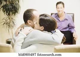 Multi-ethnic couple hugging at therapy session