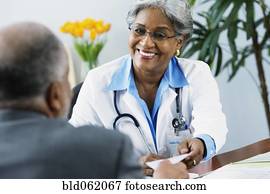 African female doctor handing prescription to patient