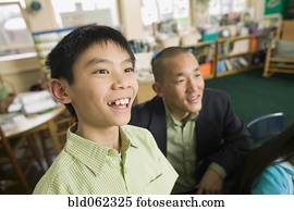 Asian son with father in classroom