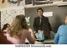 Asian teacher talking to students in classroom