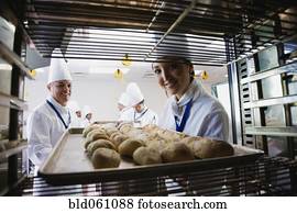 fêmea asiática, padeiro, levando, bandeja, de, pão, desligado, prateleira