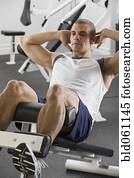 Hispanic man exercising in gym