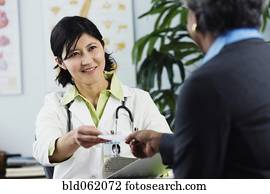 Kazakh female doctor handing prescription to patient