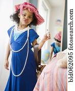 Mixed race girl playing dress-up in mother’s clothes