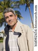 Cuban man standing in front of palm trees