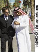 Multi-ethnic businessmen looking at cell phone