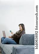 grávida, mulher asian, comprando, mercadoria, sobre, internet