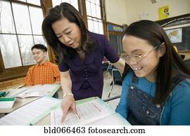 Asian school teacher helping student
