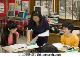 Asian school teacher helping students