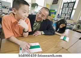 Asian school teacher helping students