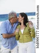 Hispanic couple kissing on beach