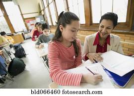 Hispanic school teacher helping student