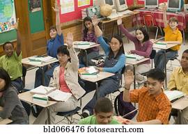 Students raising hands in classroom