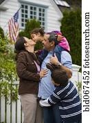 Mother kissing daughter while family watches Mother kissing daughter while family watches