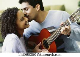 Hispanic couple with guitar kissing