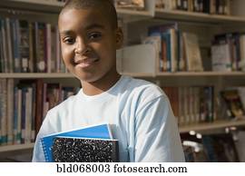 raça misturada, menino, segurando, livros, em, biblioteca